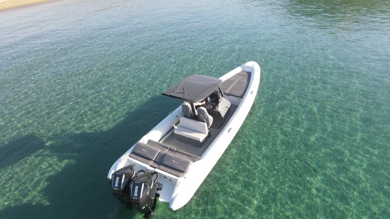 Full day cruise — the RIBCO Blade 30 anchored over turquoise water by a Saronic sandbar